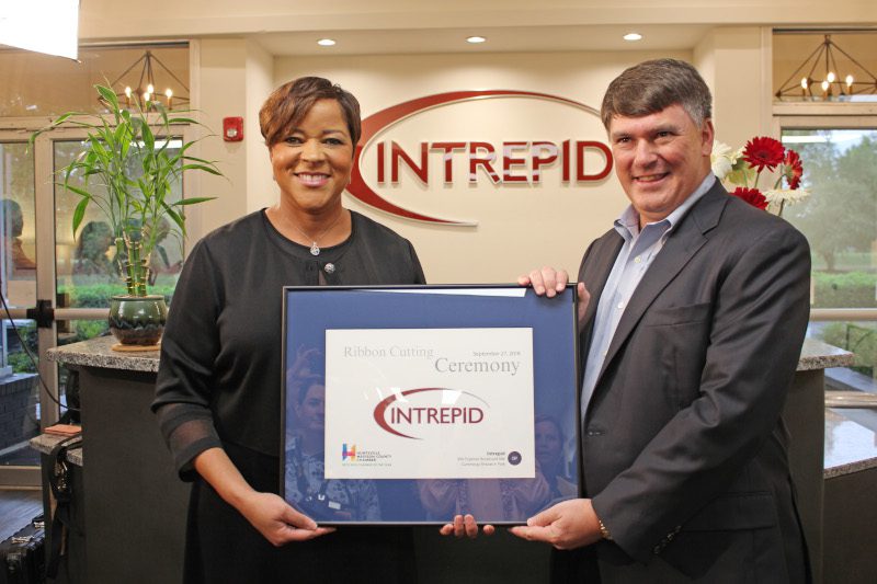 Bill Best and Kim Lewis smile with Ribbon Cutting plaque