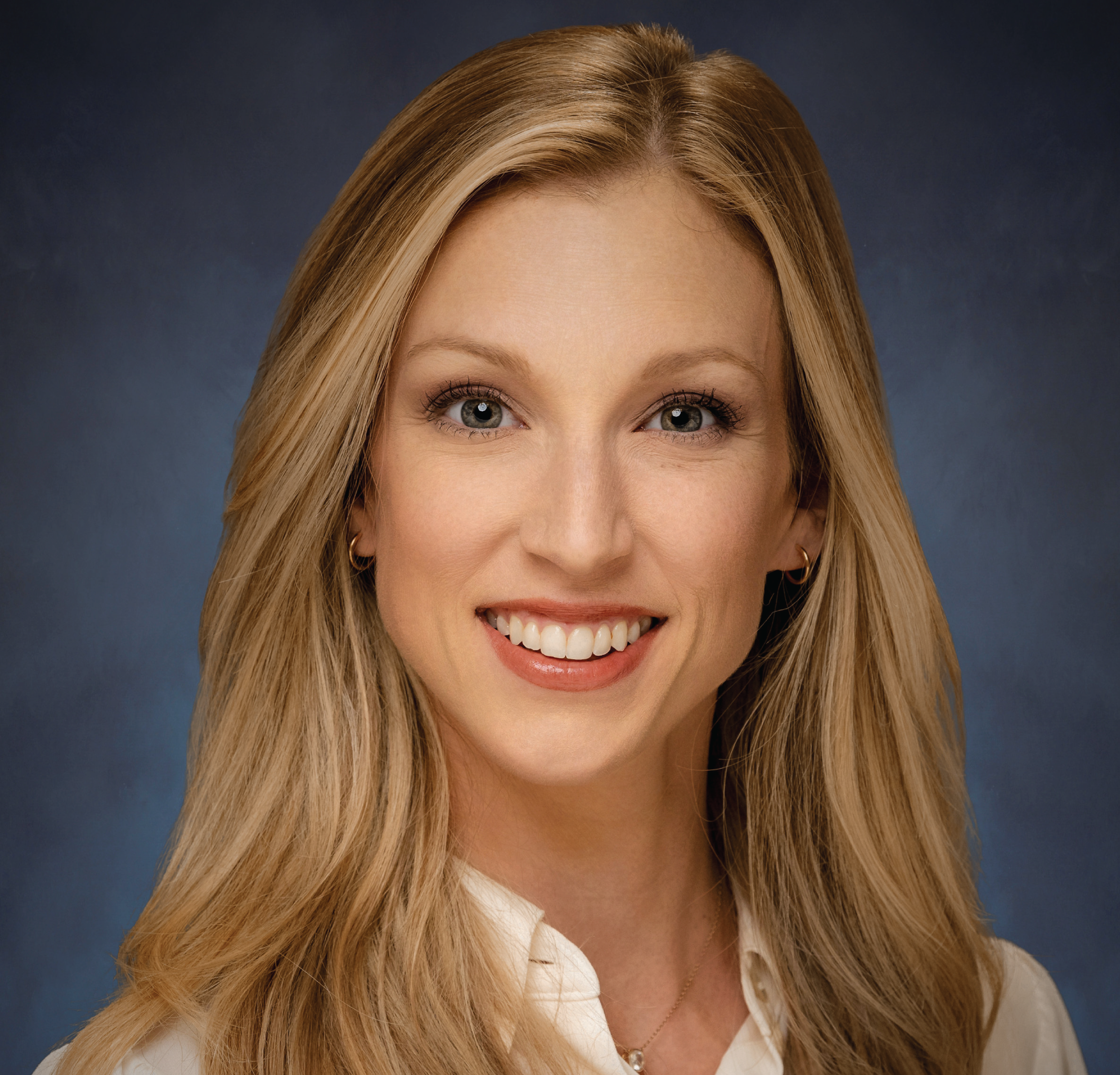 Smiling woman with blonde hair and white shirt.