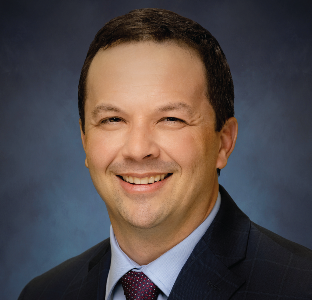 Headshot picture of a man smiling for the photograph